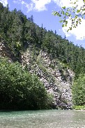 Swinging bridge across river in Italian Alps