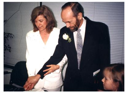 Kitty and Tom cut wedding cake