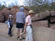 Micky locates the bobcat asleep and just visible on a rock ledge