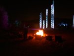 View of light towers from behind camp fire