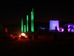 View of light towers from behind camp fire