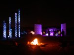 View of light towers from behind camp fire