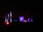 View of light towers from behind camp fire