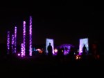 View of light towers from behind camp fire